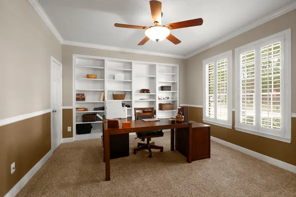 a view of a workspace with furniture and a window
