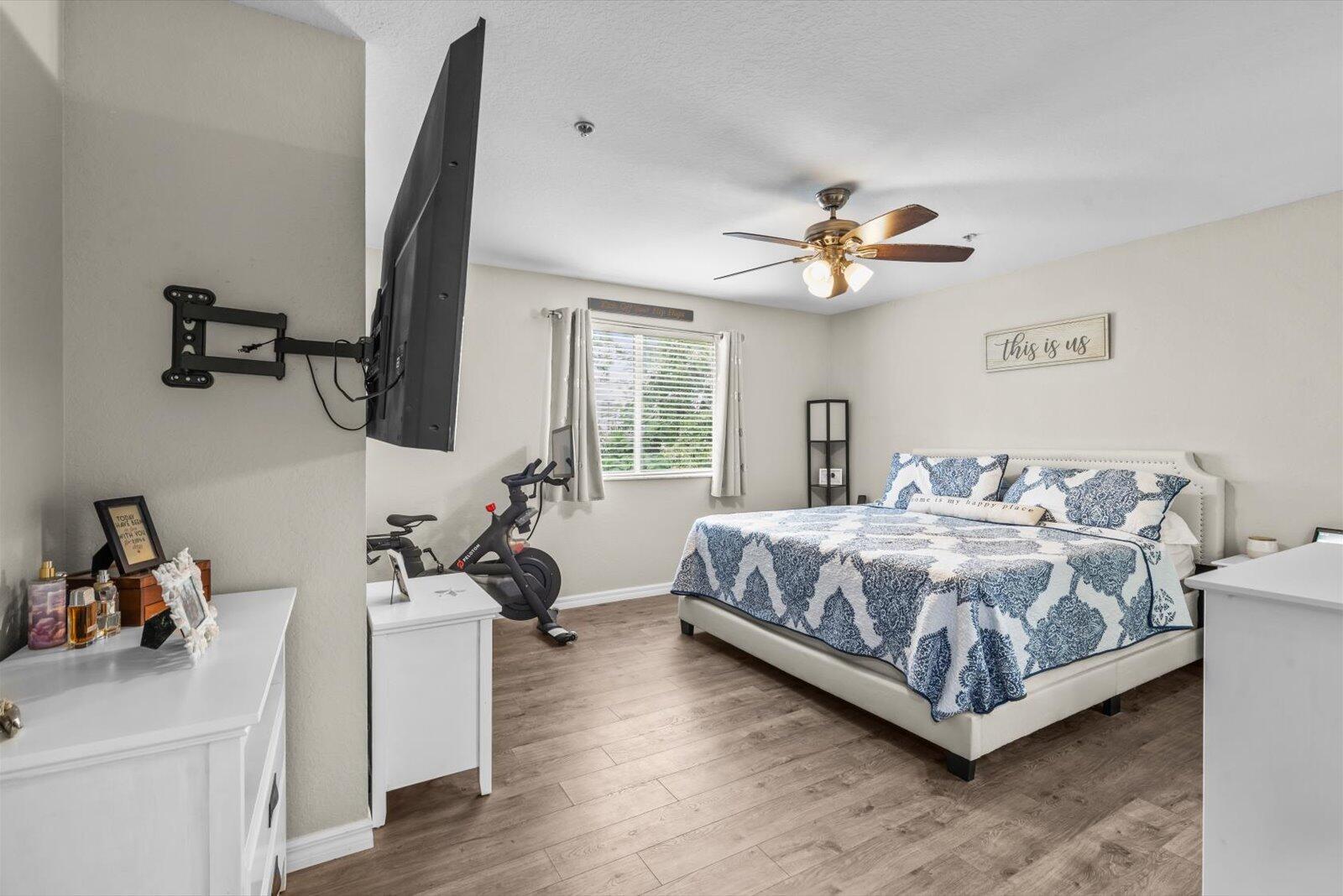 5290 Southeast Mitchell Lane Stuart, FL 34997 - Photo 16 of 43 a spacious bedroom with a bed and a chandelier