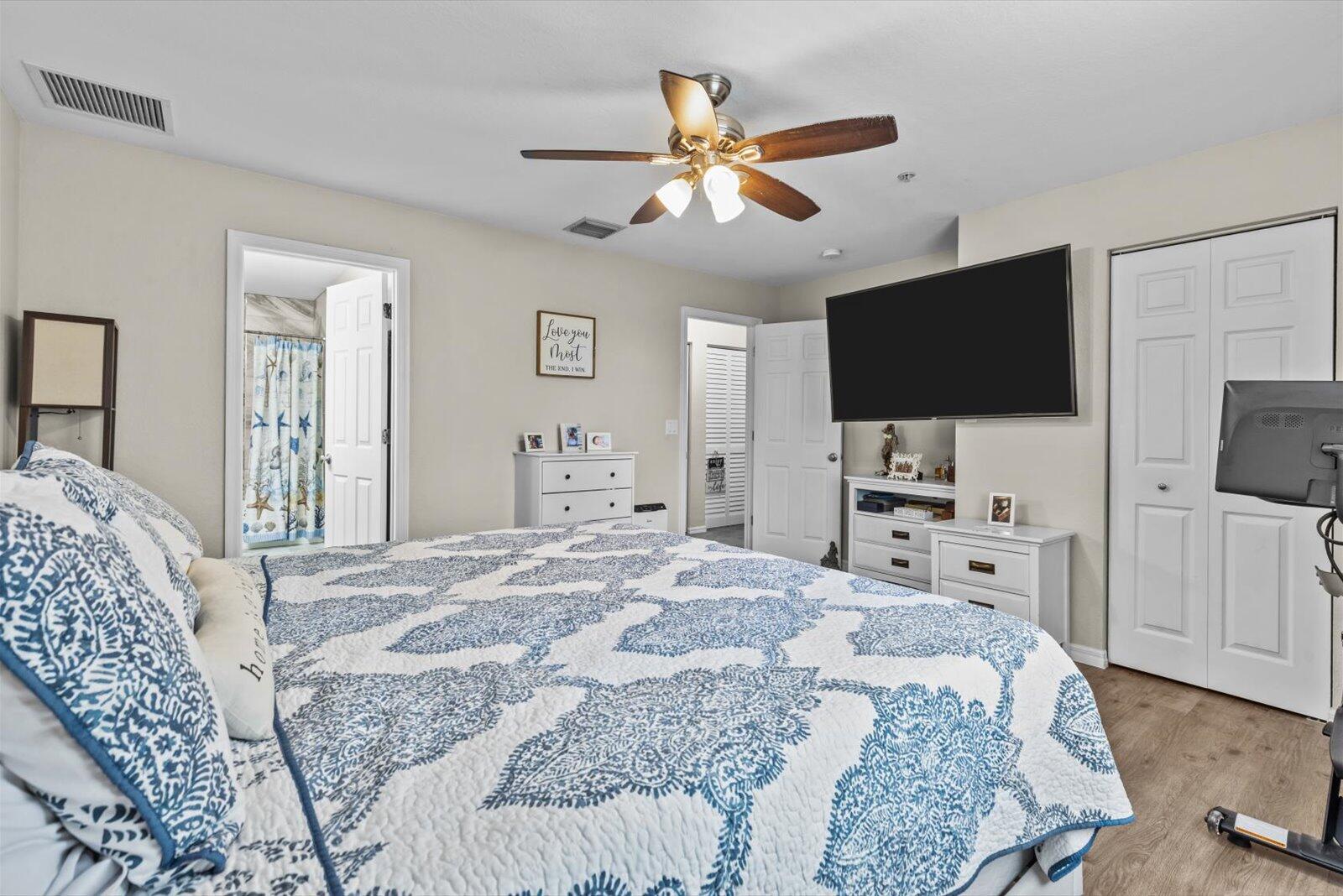 5290 Southeast Mitchell Lane Stuart, FL 34997 - Photo 18 of 43 a bedroom with a bed and a flat screen tv