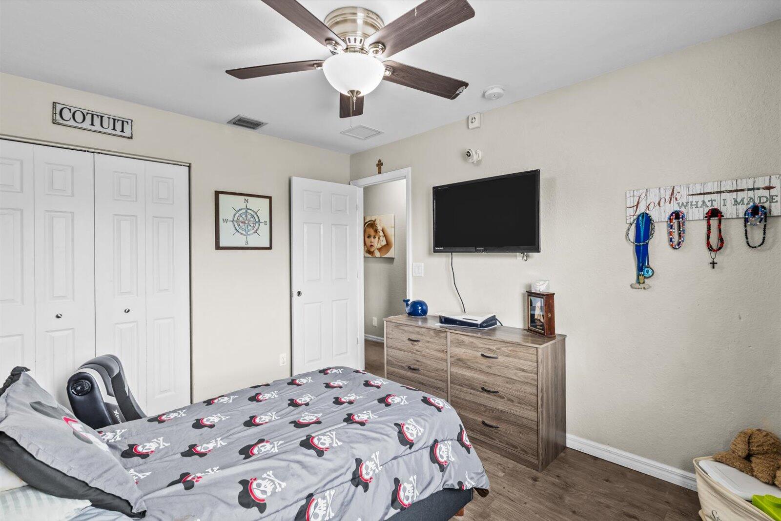 5290 Southeast Mitchell Lane Stuart, FL 34997 - Photo 21 of 43 a bedroom with a bed and a flat screen tv