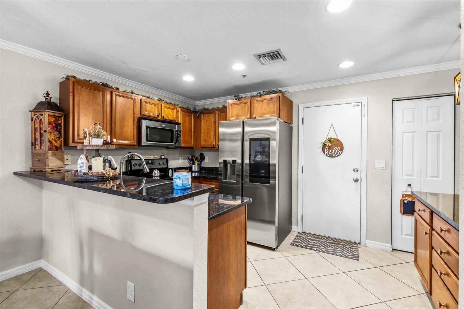 5290 Southeast Mitchell Lane Stuart, FL 34997 - Photo 9 of 43 a kitchen with stainless steel appliances granite countertop a refrigerator a stove top oven a sink and dishwasher