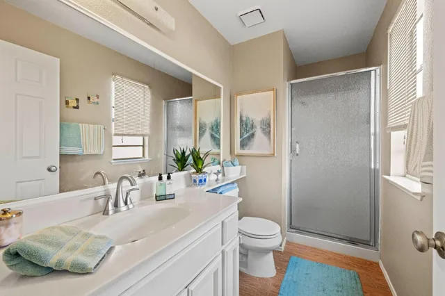 a bathroom with a sink a toilet and shower