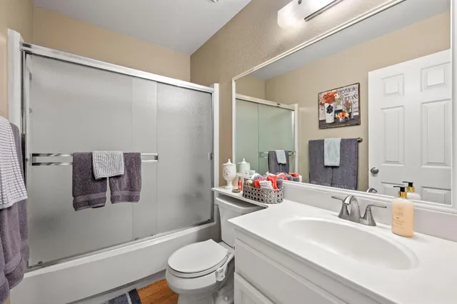 a bathroom with a sink mirror vanity and toilet