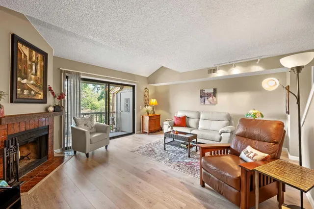 a living room with furniture a fireplace and a large window