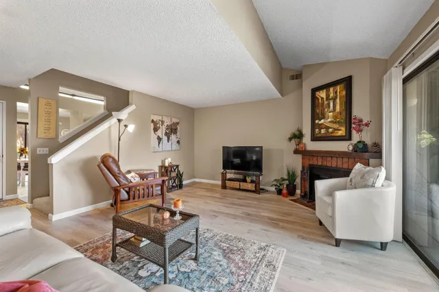 a living room with furniture a fireplace and a flat screen tv
