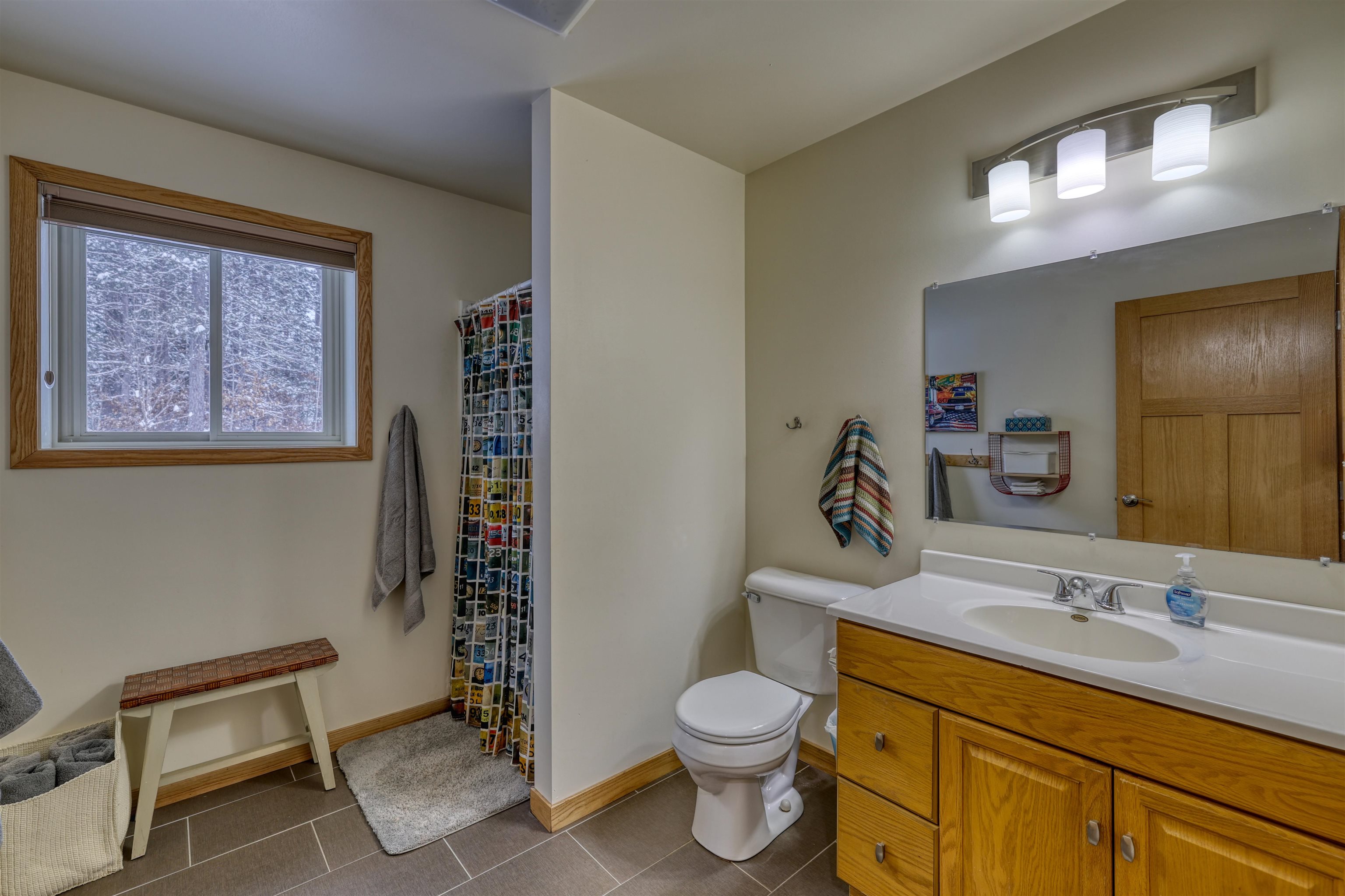 8056 North North Road Springbrook, WI 54875 - Photo 35 of 65 Full bath with curtained shower, vanity, and dark tile patterned flooring