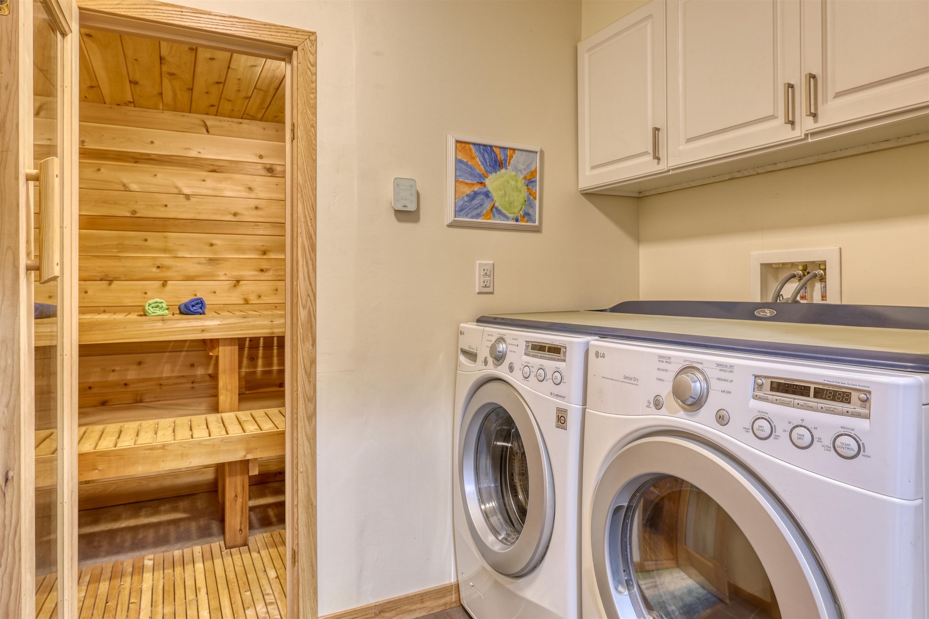 8056 North North Road Springbrook, WI 54875 - Photo 36 of 65 Laundry room featuring a relaxing sauna, cabinet space, washing machine and dryer, and light wood-type flooring