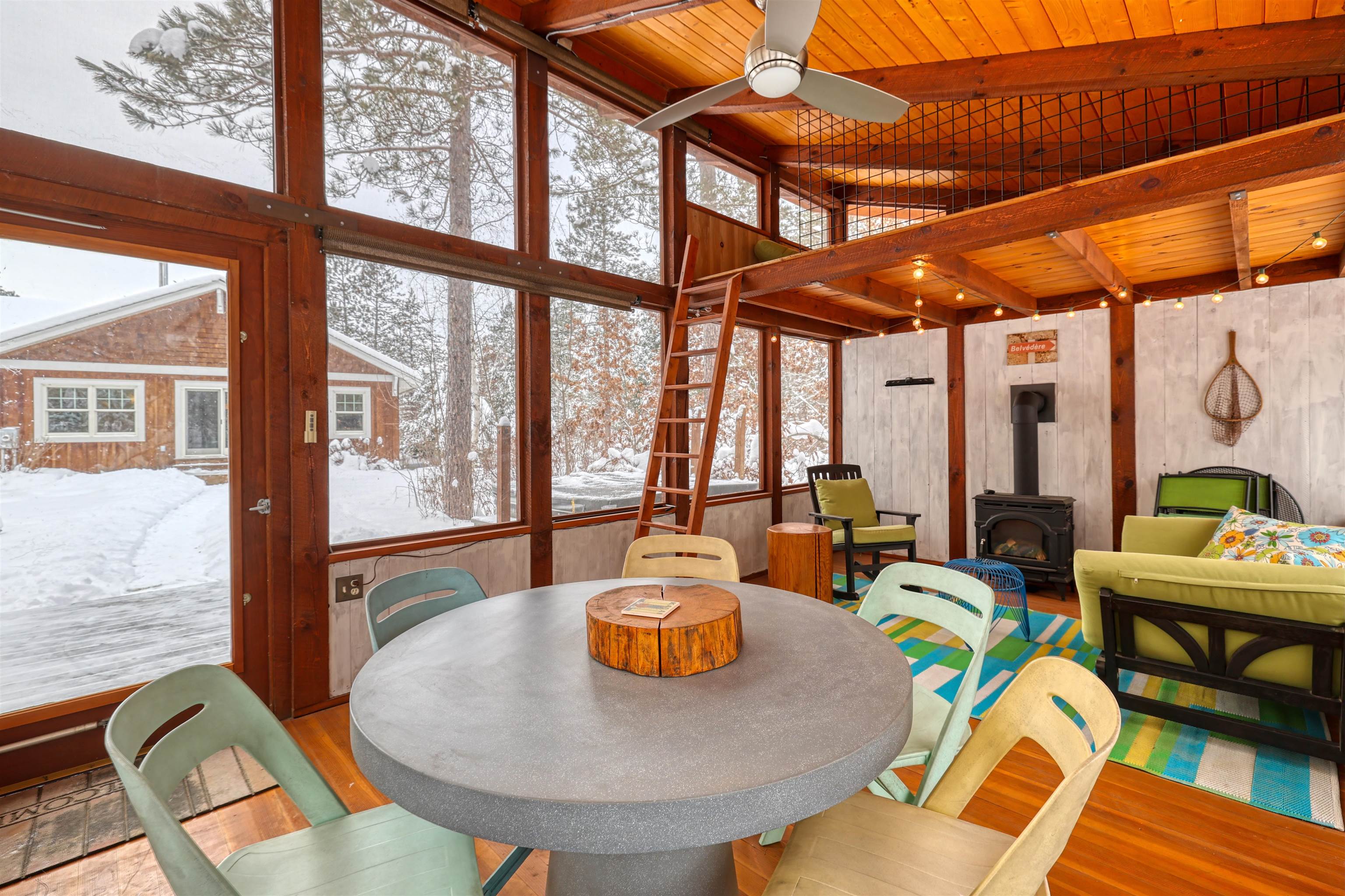 8056 North North Road Springbrook, WI 54875 - Photo 40 of 65 Sunroom featuring a wood stove, a wooden ceiling with exposed beams, wood walls, high vaulted ceiling, and wood finished floors