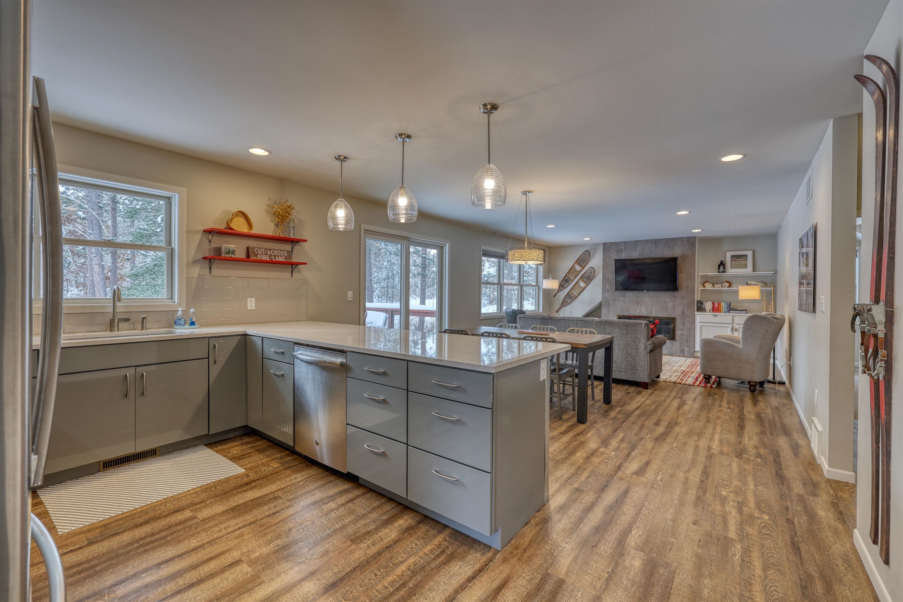 8056 North North Road Springbrook, WI 54875 - Photo 48 of 65 Kitchen featuring gray cabinets, a peninsula, a fireplace, appliances with stainless steel finishes, and light wood-type flooring