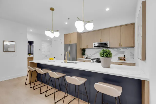 a room with stainless steel appliances kitchen island a table and chairs in it