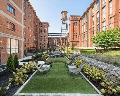 a view of a large building with a big yard and potted plants