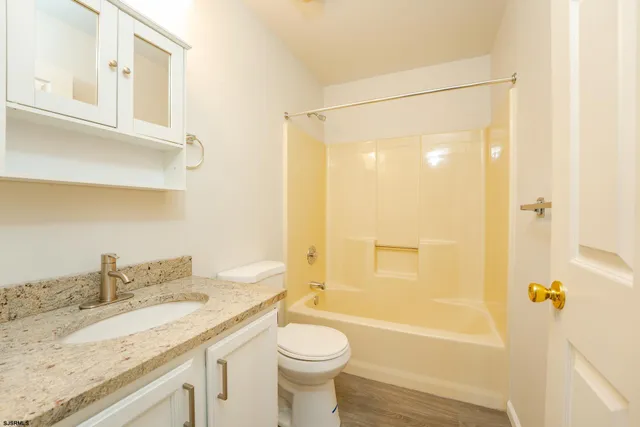 a bathroom with a granite countertop sink toilet and shower