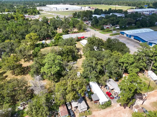 an aerial view of residential houses with outdoor space and trees
