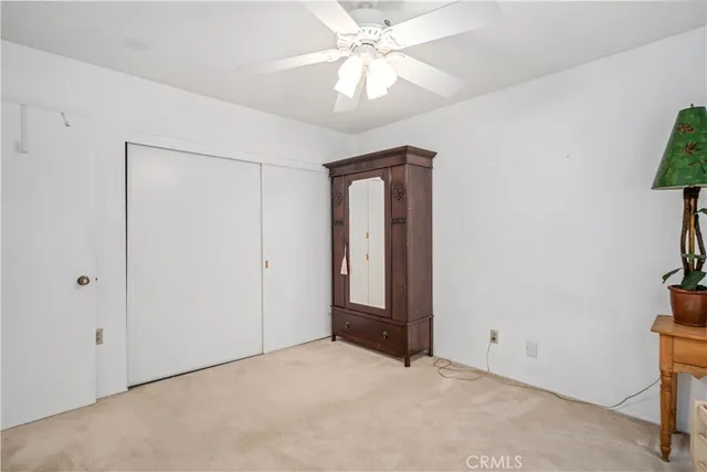 an empty room with closet and a chandelier fan