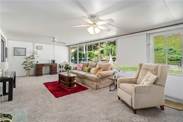 a living room with furniture a table and a large window