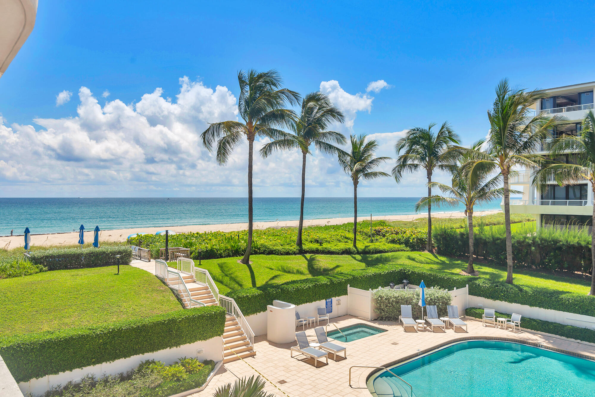 2580 South Ocean Boulevard, Unit 1C3 Palm Beach, FL 33480 - Photo 13 of 17 a view of a swimming pool with a lawn chairs under an umbrella