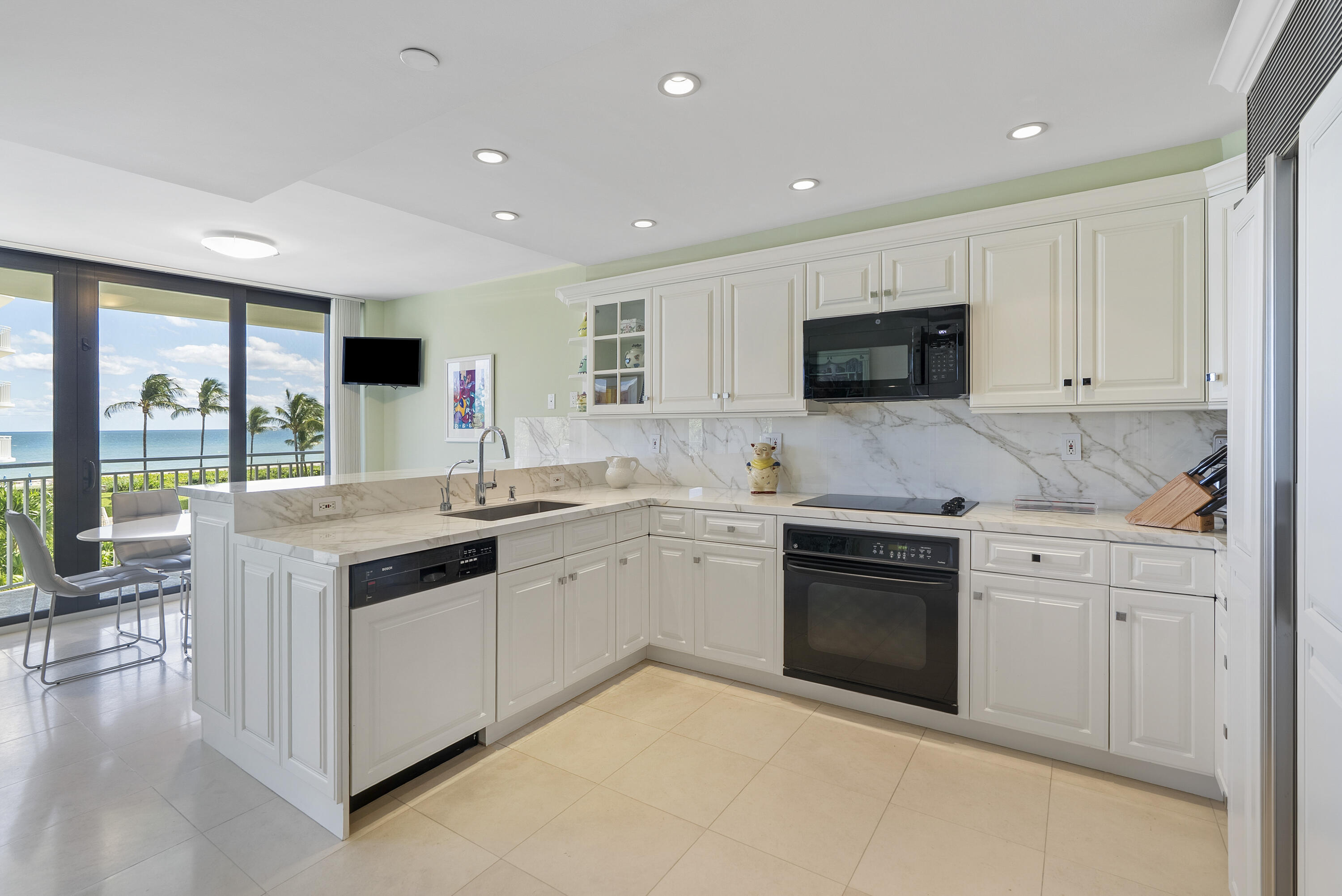 2580 South Ocean Boulevard, Unit 1C3 Palm Beach, FL 33480 - Photo 7 of 17 a kitchen with granite countertop a stove top oven sink and cabinets
