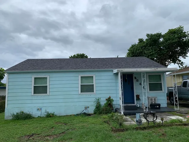 a view of backyard with table and chairs and potted plants