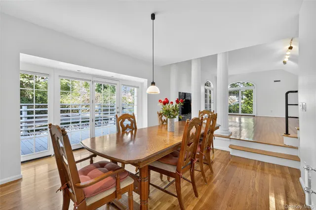 a dining room with furniture a chandelier and wooden floor
