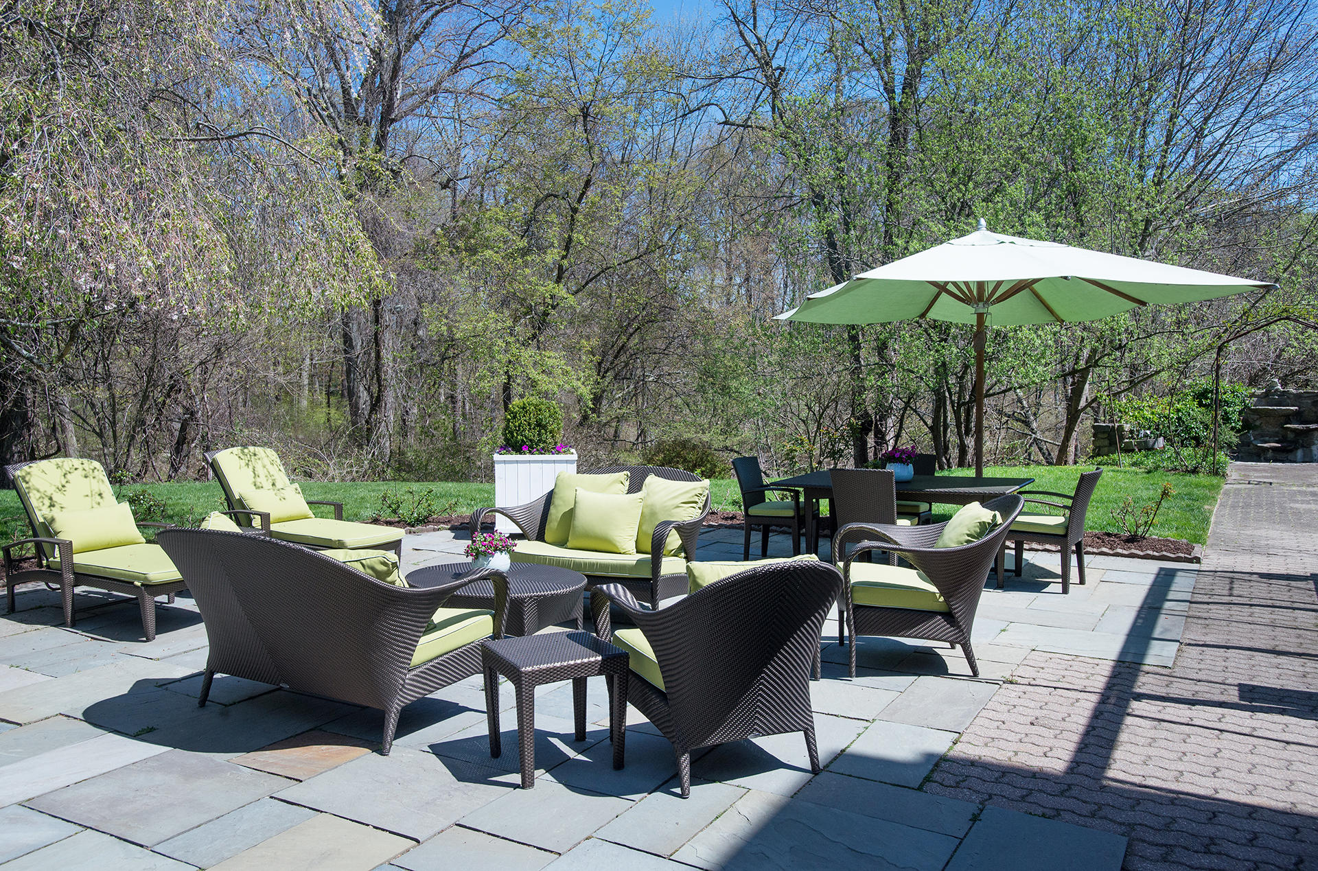 65 Sunset Hill Road New Canaan, CT 06840 - Photo 20 of 21 a view of a patio with chairs and a table under an umbrella