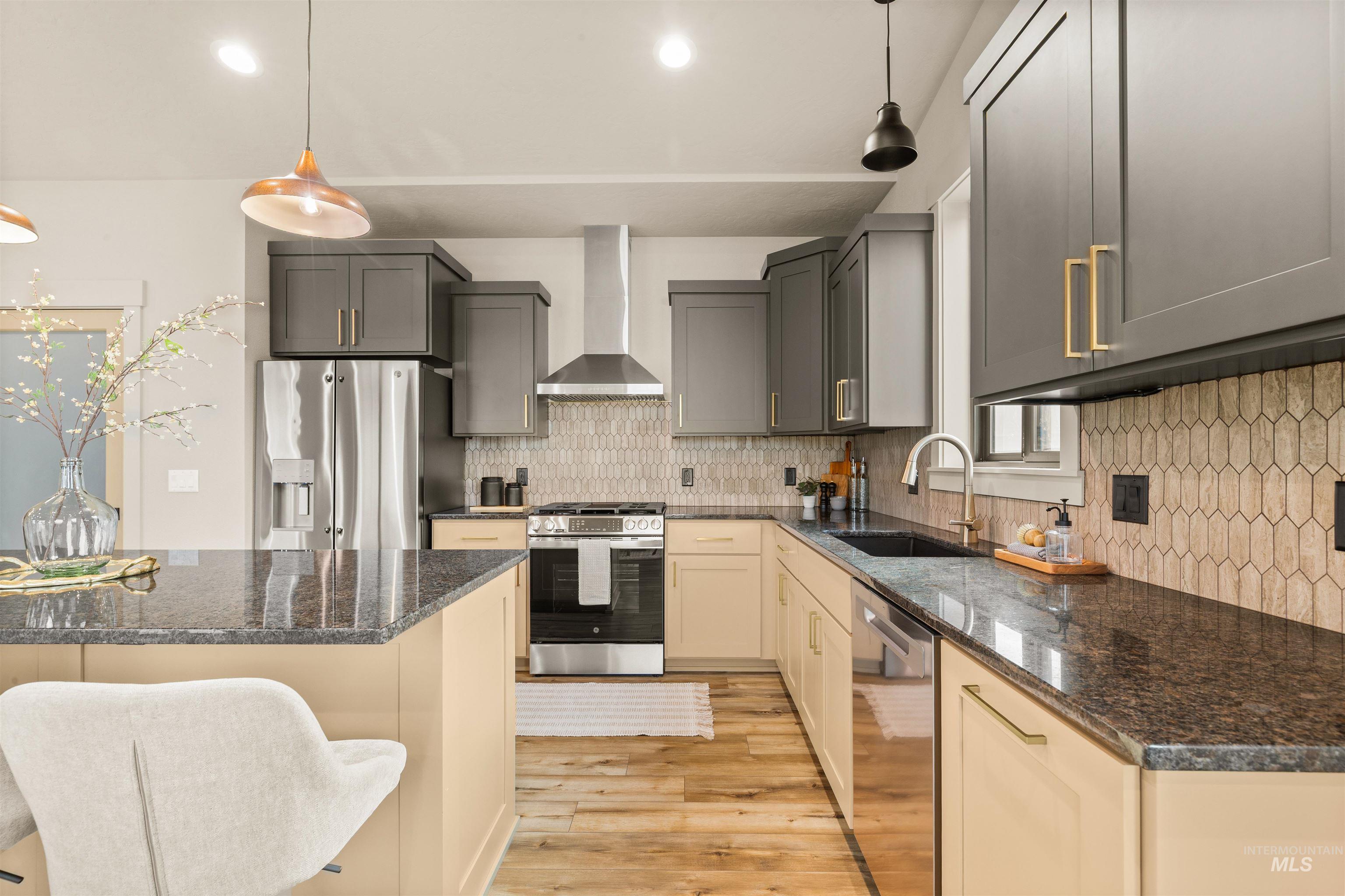 335 Warner Avenue Lewiston, ID 83501 - Photo 13 of 43 Kitchen with stainless steel appliances, decorative light fixtures, dark stone counters, and light wood-style floors