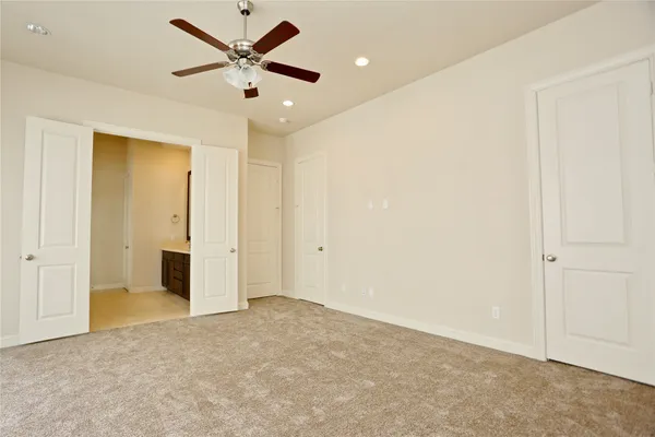 an empty room with closet and a ceiling fan