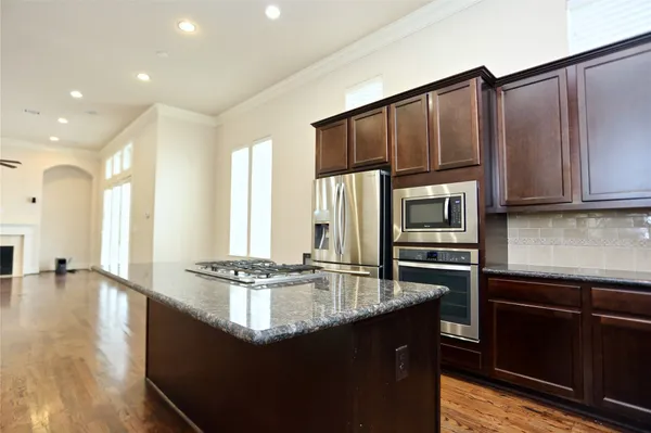 a kitchen with granite countertop a sink cabinets and stainless steel appliances