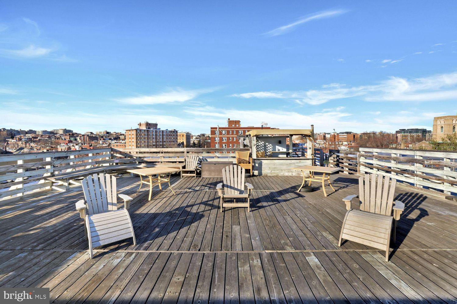 1725 17th Street Northwest, Unit 503 Washington, DC 20009 - Photo 19 of 24 a view of a rooftop deck with chairs and wooden floor