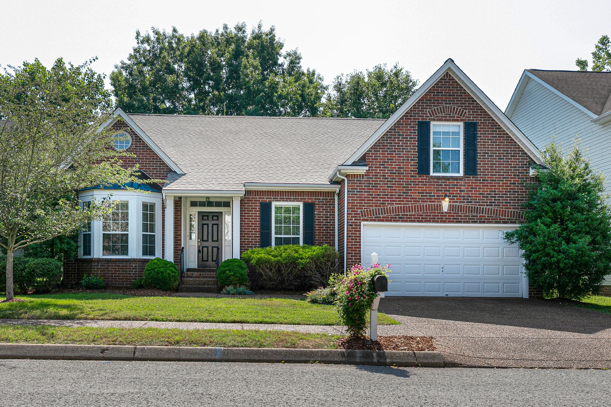 a front view of a house with a garden and plants