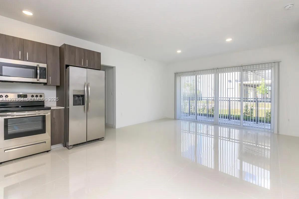 25850 Southwest 140th Court, Unit 6111 Homestead, FL 33032 - Photo 5 of 25 a kitchen with stainless steel appliances a refrigerator and a stove top oven