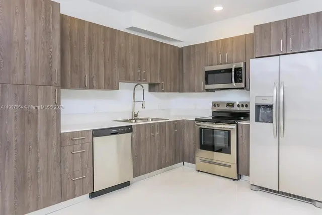 a kitchen with stainless steel appliances a stove microwave and sink