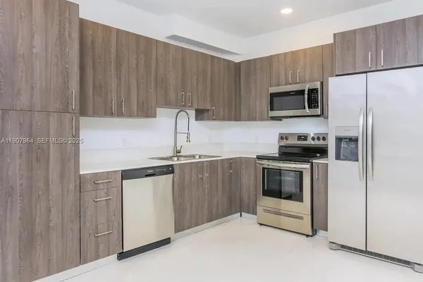 a kitchen with stainless steel appliances a stove microwave and sink
