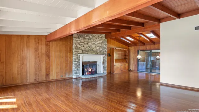 a view of a room with wooden floor a fireplace and window