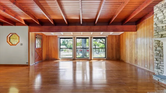 a view of empty room with wooden floor