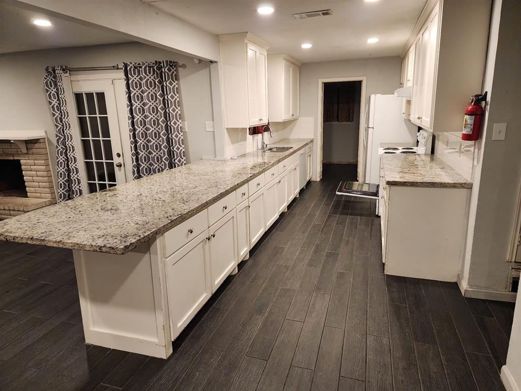 a large kitchen with kitchen island granite countertop a large counter top and sink