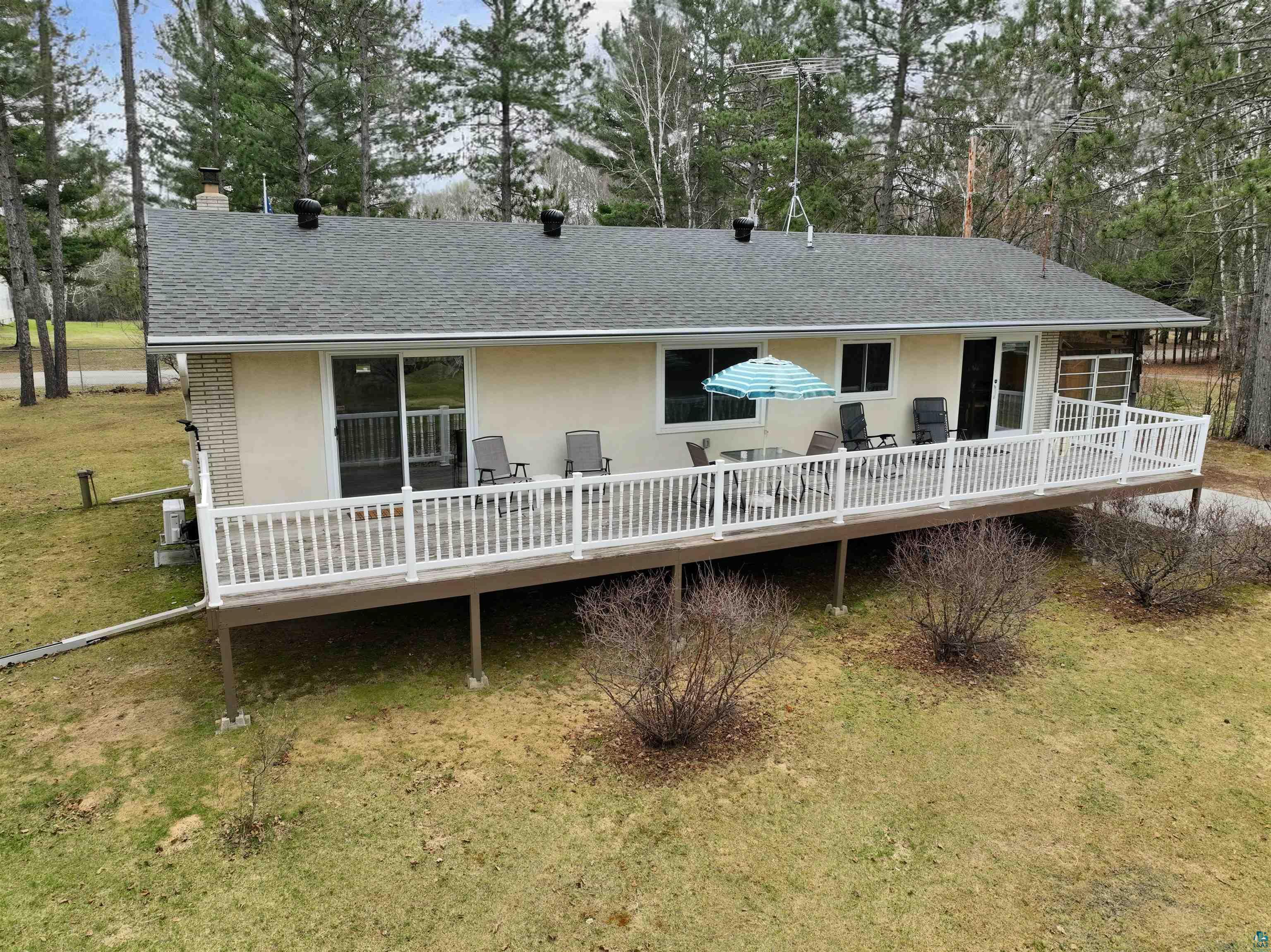 3975 Long Lake Shores Road Eveleth, MN 55734 - Photo 63 of 84 Rear exterior featuring an elevated deck with white railings, multiple sliding glass doors, and a stucco finish