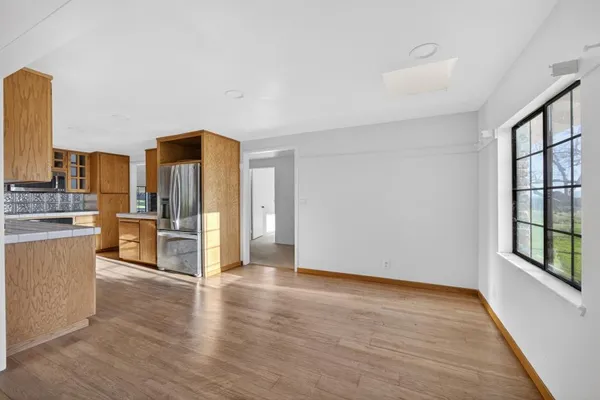 a view of a kitchen with a sink and dishwasher a refrigerator with wooden floor