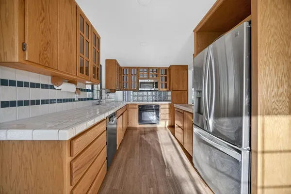 a kitchen with stainless steel appliances granite countertop a refrigerator and a sink