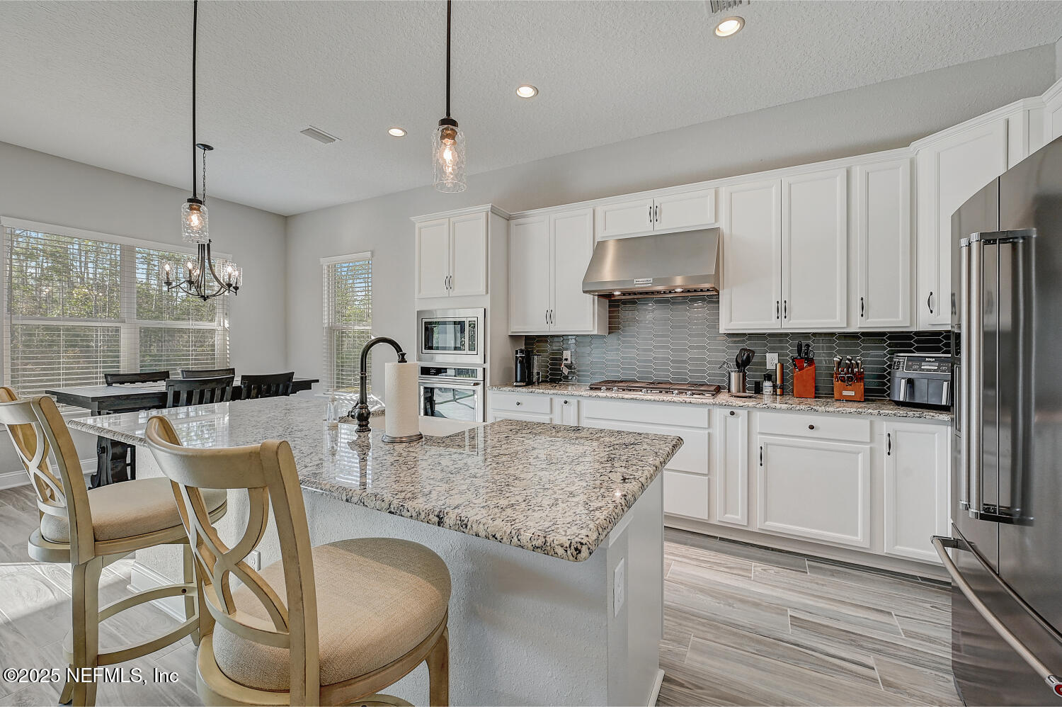 264 Vly Fls Way St. Johns, FL 32259 - Photo 15 of 37 a kitchen with stainless steel appliances granite countertop a stove top oven a refrigerator a sink and white cabinets with wooden floor