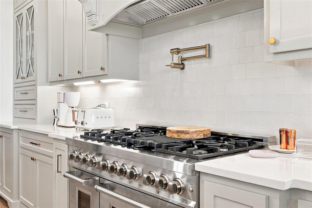 803 Willow Moon Ranch Road Crawford, TX 76638 - Photo 4 of 37 Professional-grade stainless steel range with a pot filler, set against a white subway tile backsplash
