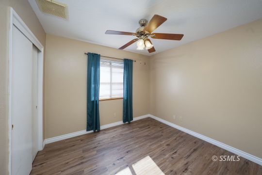 336 North Kern Street Ridgecrest, CA 93555 - Photo 14 of 35 an empty room with wooden floor fan and windows