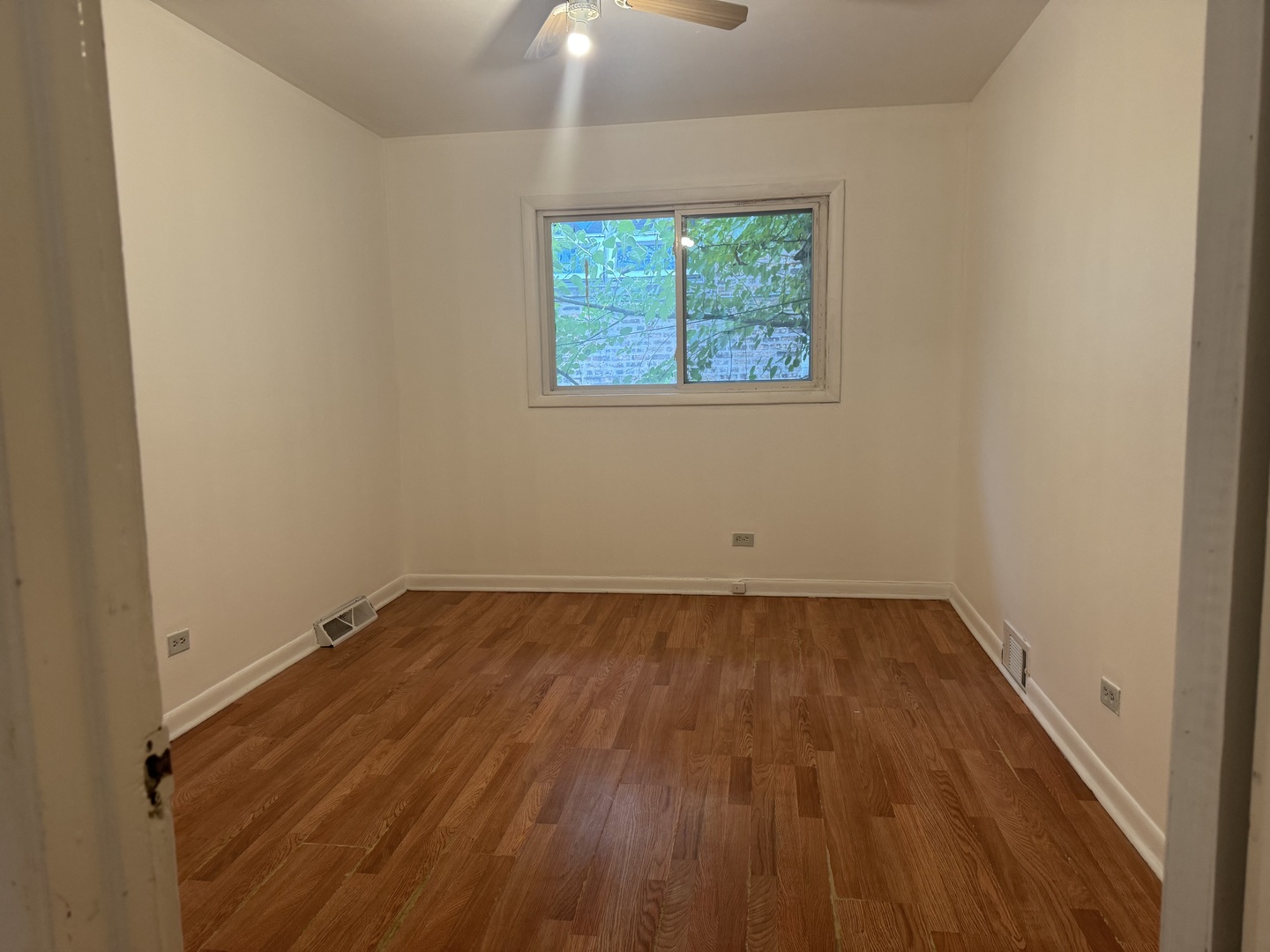 1634 West Morse Avenue, Unit C Chicago, IL 60626 - Photo 15 of 27 an empty room with wooden floor and windows