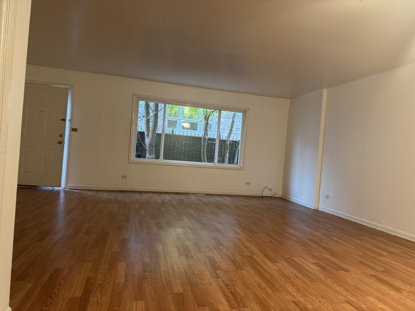 1634 West Morse Avenue, Unit C Chicago, IL 60626 - Photo 6 of 27 an empty room with wooden floor and windows