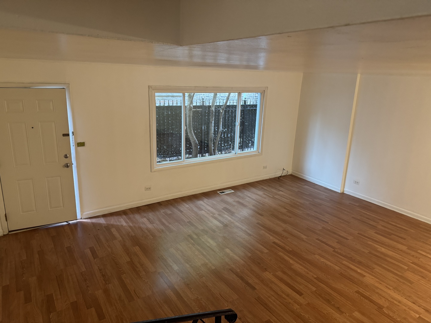 1634 West Morse Avenue, Unit C Chicago, IL 60626 - Photo 8 of 27 a view of an empty room with wooden floor and a window