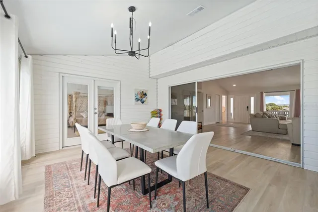 a view of a dining room with furniture a chandelier and wooden floor