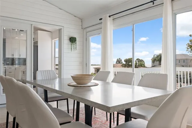 a kitchen with a table chairs refrigerator and cabinets