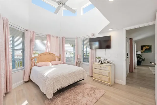 a bedroom with a bed and a flat tv screen on dresser