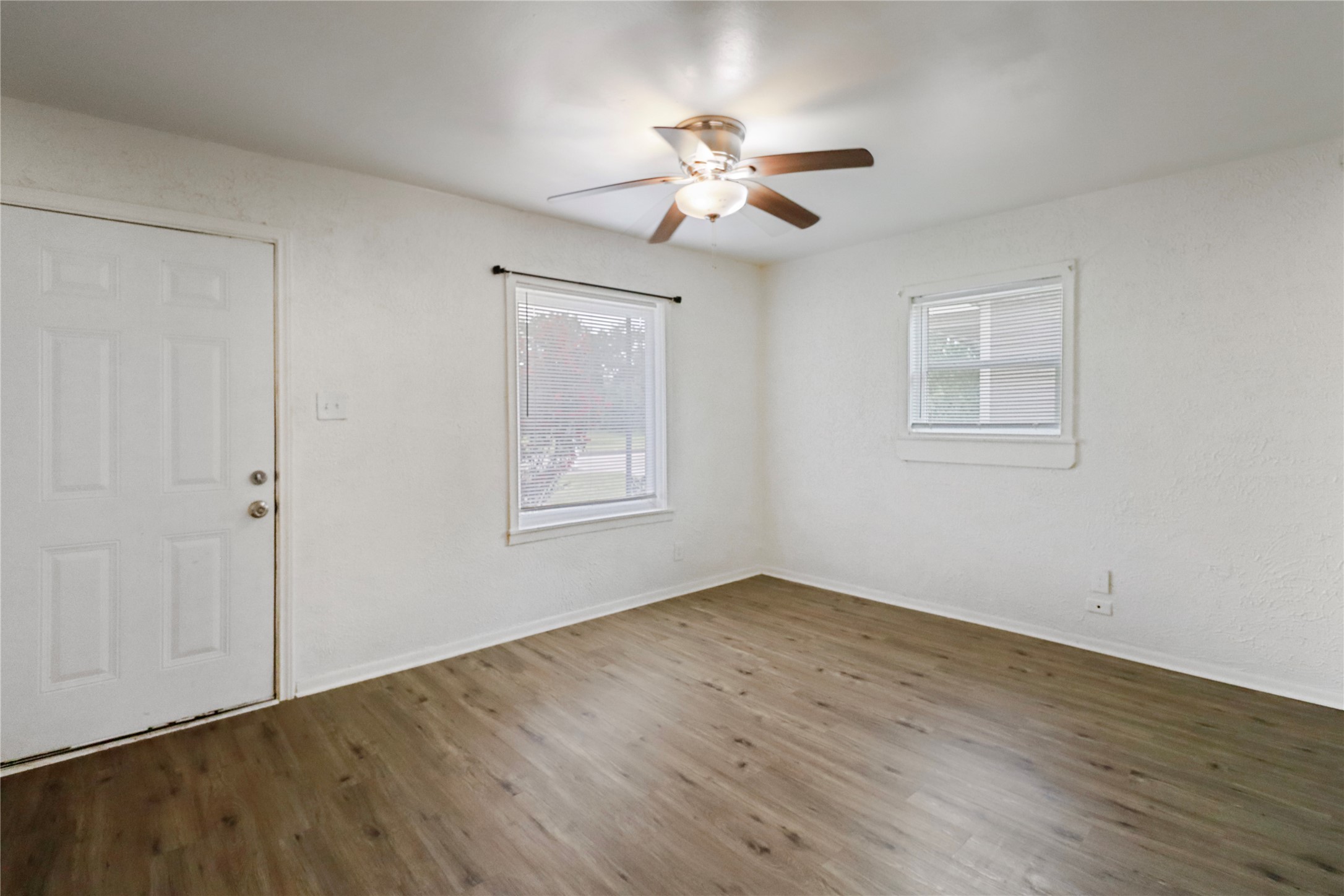 604 West Peach Street Angleton, TX 77515 - Photo 7 of 15 a view of an empty room with wooden floor and a window