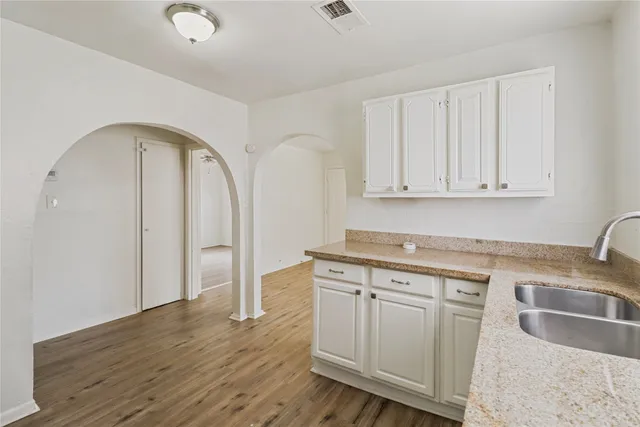 a kitchen with stainless steel appliances granite countertop a sink a stove a refrigerator and cabinets