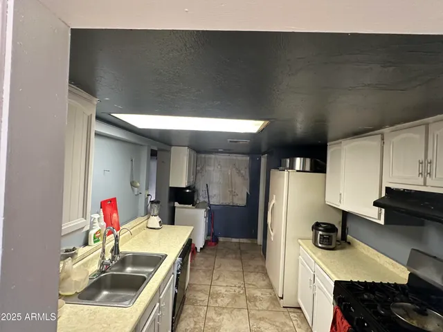 a kitchen with stainless steel appliances a sink dishwasher and a refrigerator